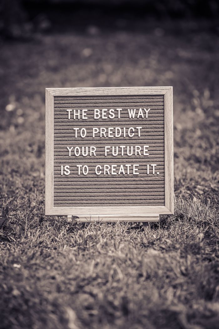 Services Letter board with motivational quote on grass background in black and white.